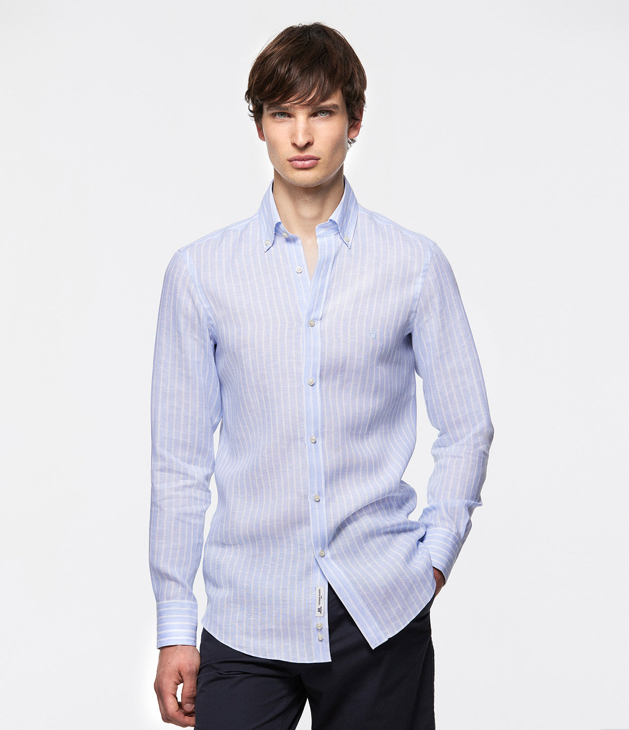 fotografía modelo de pie mano bolsillo con camisa azul cielo rayas blancas