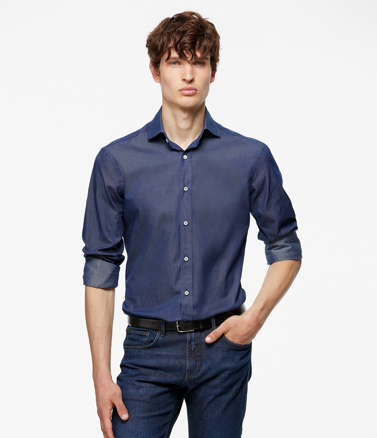 modelo de pie con las mangas de la camisa arremangadas