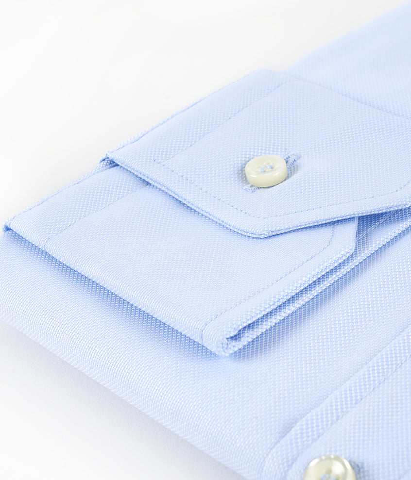 foto detalle puño camisa doblada azul cielo